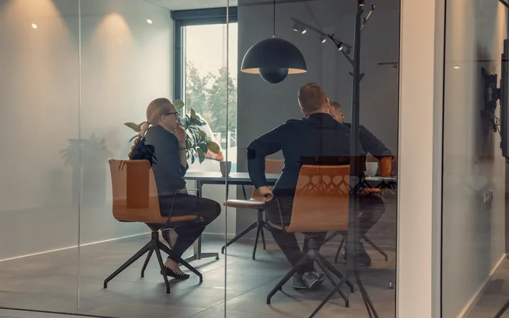 To personer i møde i et glasmødelokale hos Dansk Motor Finans