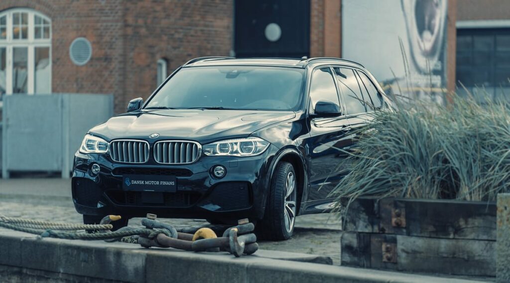 a black car parked in front of a brick building