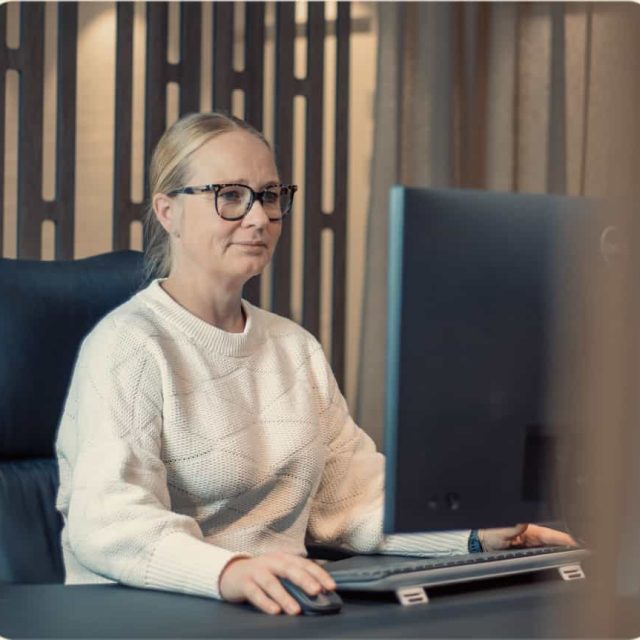 a woman sitting at a desk with a computer