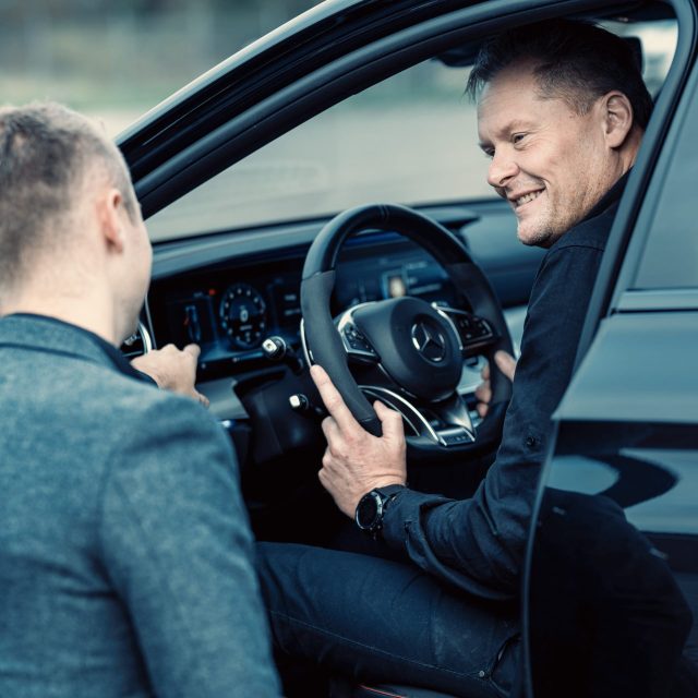 a man sitting in a car smiling